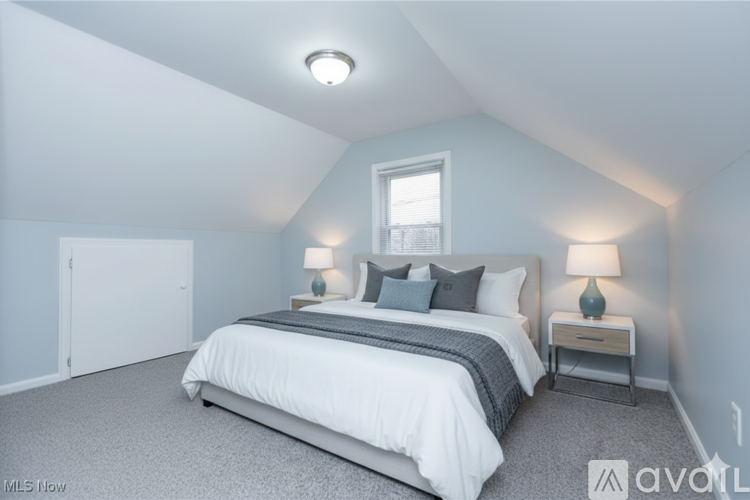 A bedroom with a bed, nightstands, and a window.