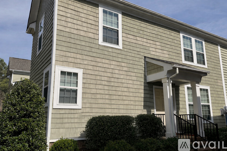 A house with a grey siding and white trim is available for purchase.