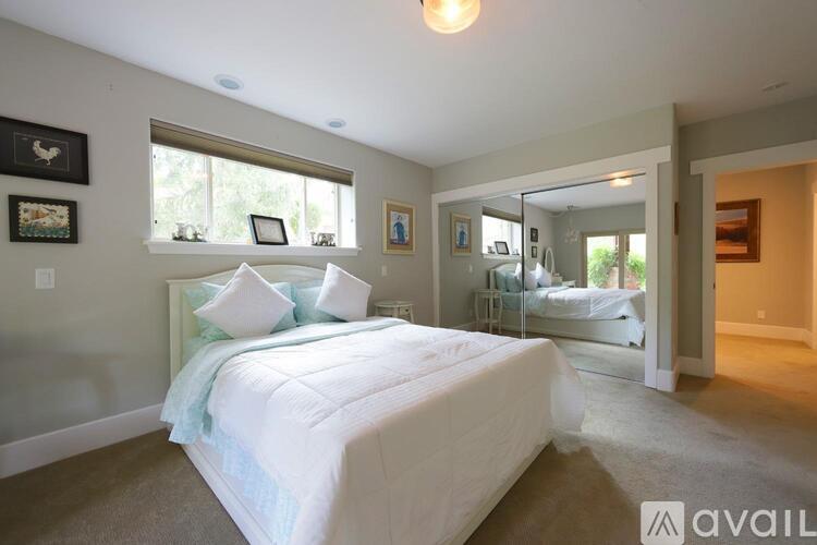 A bedroom with a large bed and a mirror on the wall.