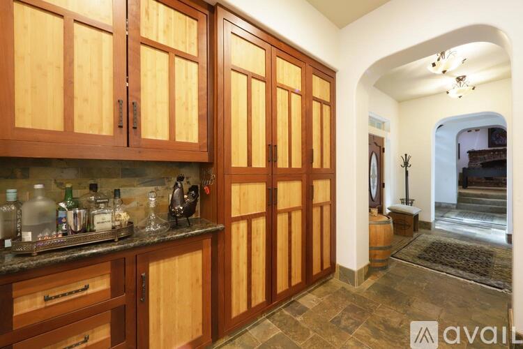 A kitchen with wooden cabinets and a bar area.