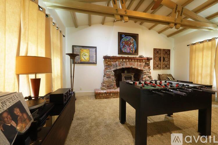 A room with a pool table and a fireplace.