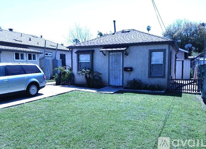 A house with a grey car parked in front.