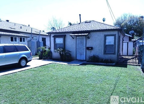 A house with a grey car parked in front.