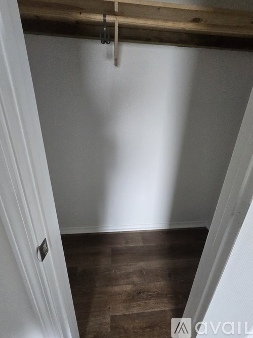A room with a wooden beam on the ceiling and a white door.