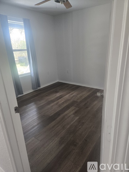 A room with wooden flooring and a ceiling fan.