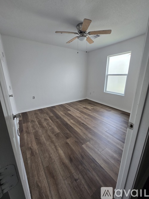 A room with wooden flooring and a ceiling fan.