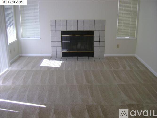 A room with a fireplace and a carpeted floor.