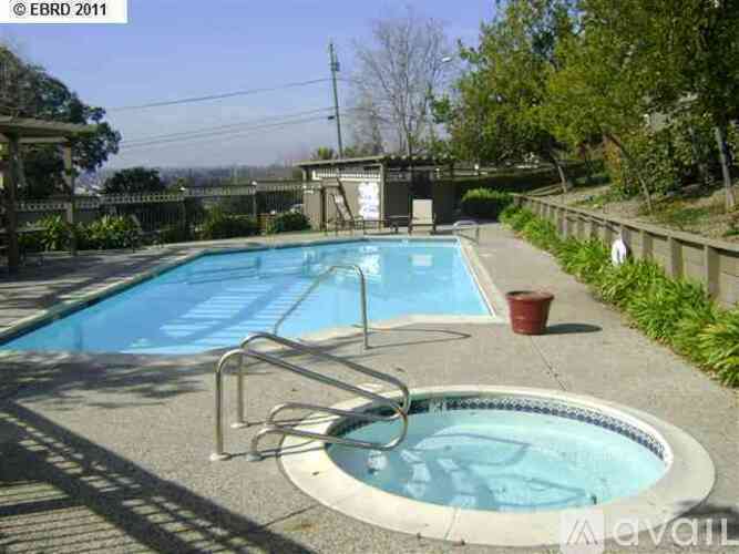 A small pool with a hot tub in the middle of it.