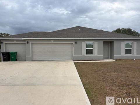 A house with a grey roof and a white garage door.