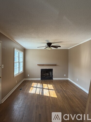 A room with a fireplace and a ceiling fan.