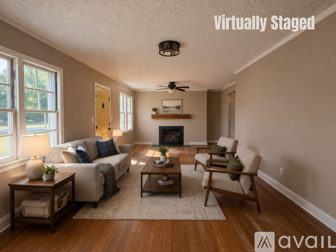 A living room with a couch, chairs, and a fireplace.