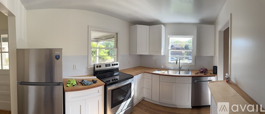 A kitchen with white cabinets and a stainless steel refrigerator.