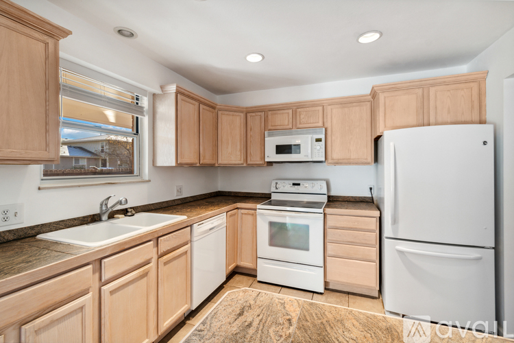 A kitchen with wooden cabinets and white appliances.
