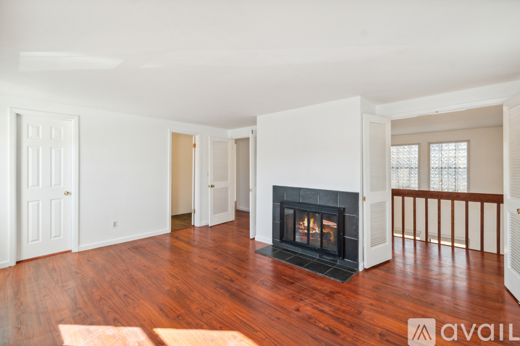 A living room with a fireplace and hardwood floors.