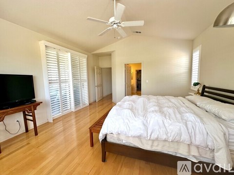 A bedroom with a large bed and a television.