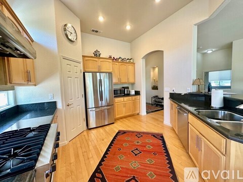 A kitchen with wooden cabinets and a stainless steel refrigerator.