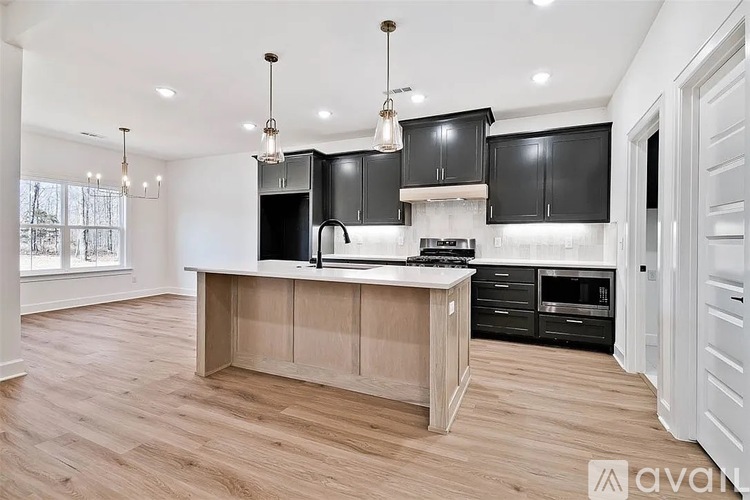A kitchen with black cabinets and a wooden island.