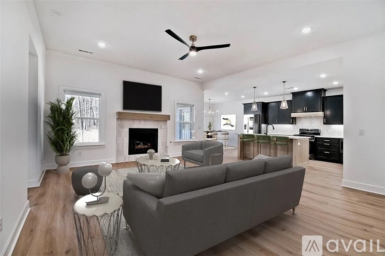 A living room with a grey couch and a television mounted on the wall.