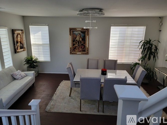 A living room with a couch, chairs, and a dining table.