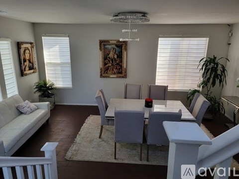 A living room with a couch, chairs, and a dining table.