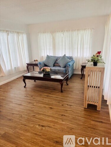A living room with a blue couch and wooden floors.