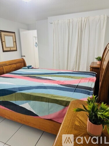 A bedroom with a bed and a potted plant.