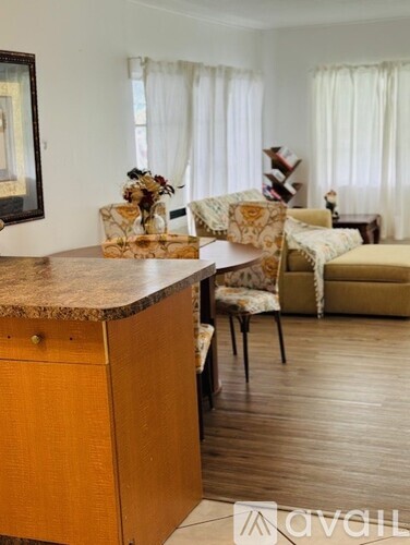 A kitchen with a wooden island and a dining table with chairs.