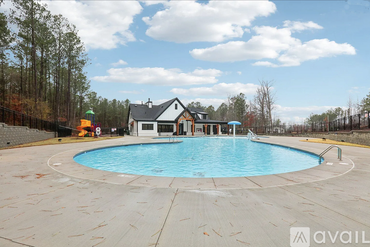 A swimming pool in a backyard with a house in the background.