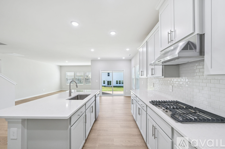 A modern kitchen with white cabinets and a large island.
