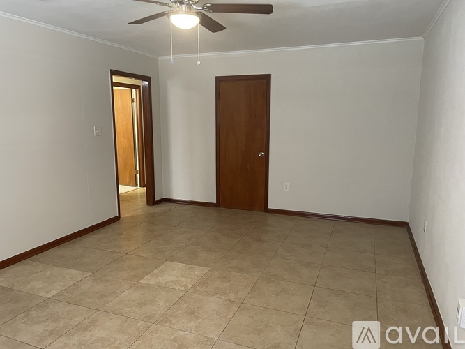 A room with a ceiling fan and tile flooring.
