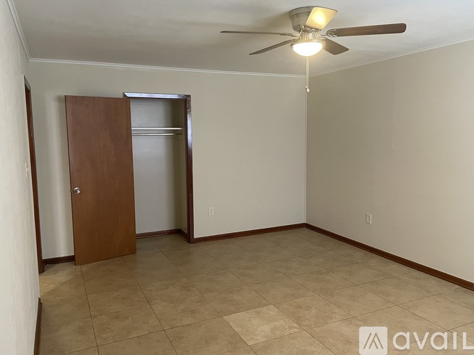 A room with a ceiling fan and a brown door.