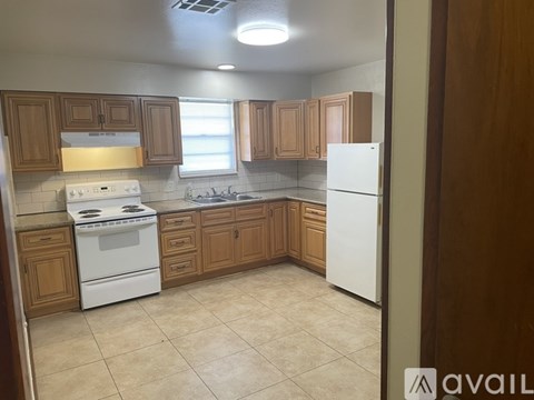 A kitchen with wooden cabinets and white appliances.