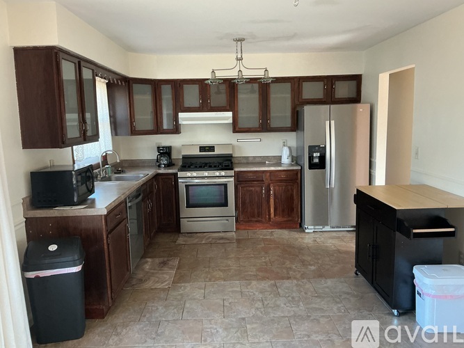 A kitchen with brown cabinets and a black fridge.