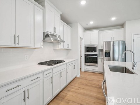 A kitchen with white cabinets and stainless steel appliances.