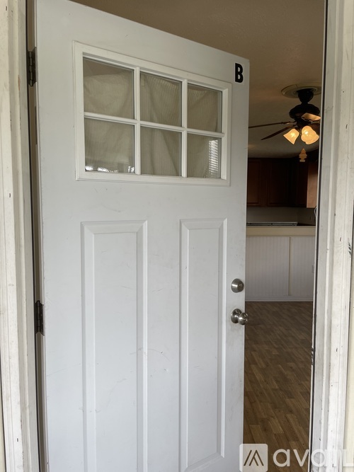 A white door with a glass window and a letter B above it.