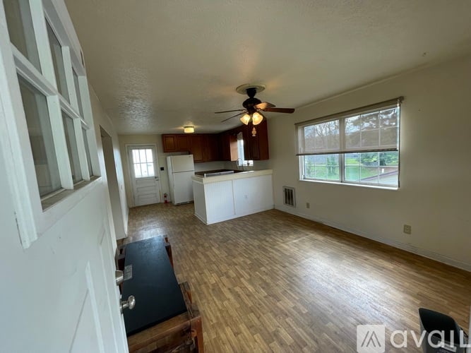 A living room with a ceiling fan and wooden flooring.