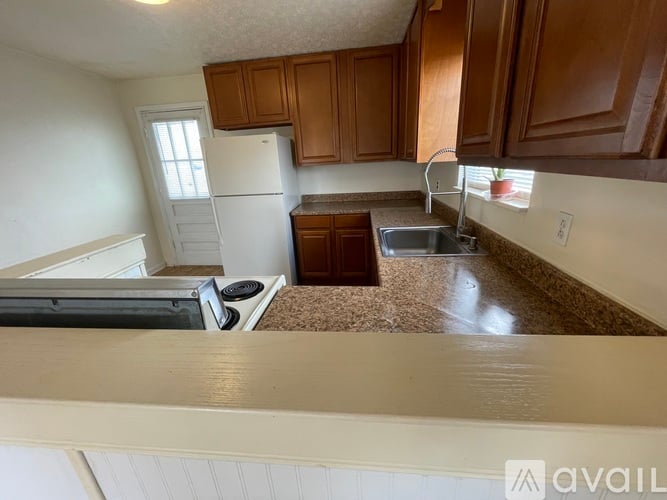 A kitchen with brown cabinets and a white refrigerator.