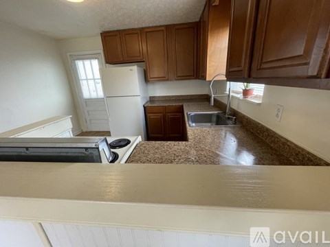 A kitchen with brown cabinets and a white refrigerator.