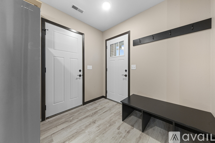 A hallway with two doors and a bench.