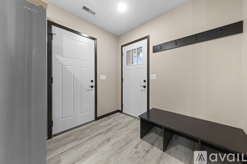 A hallway with two doors and a bench.