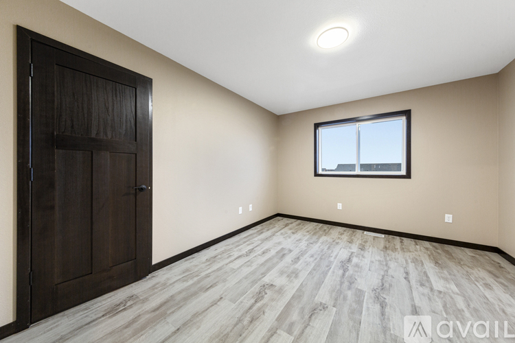A room with a wooden floor and a window with a view of a building outside.