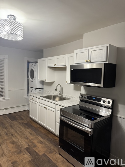 A kitchen with black appliances and white cabinets.
