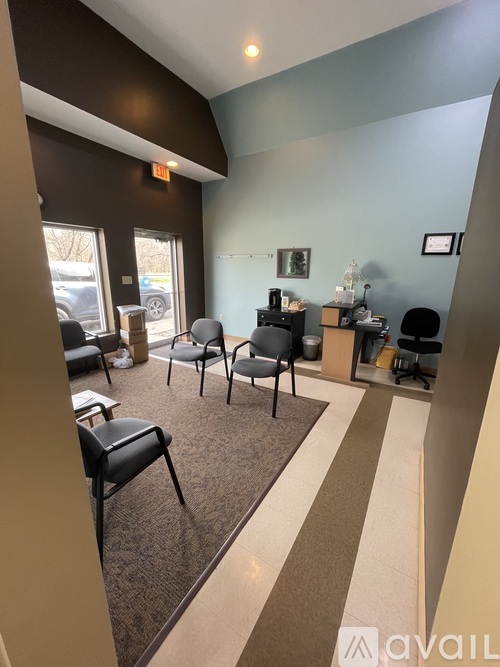 A waiting room with chairs and a table with a bottle on it.