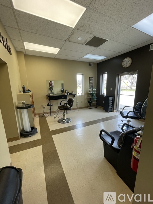 A hair salon with black chairs and a white counter.