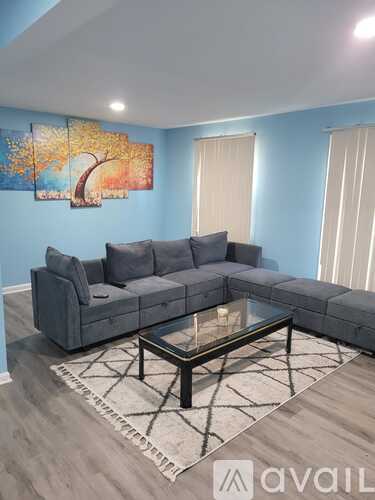 A living room with a grey sofa and a glass coffee table.