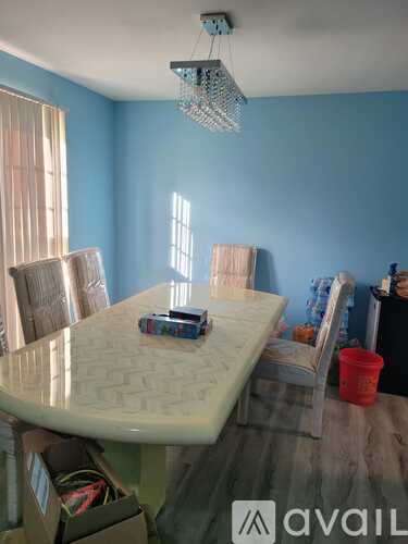 A dining room with a table and chairs.