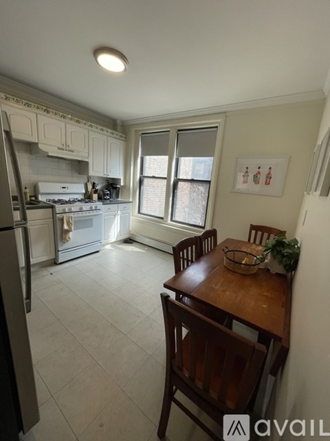 A kitchen with a refrigerator, stove, and table.