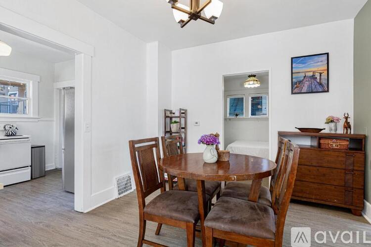 A dining room with a wooden table and chairs.