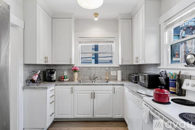 A kitchen with white cabinets and appliances.