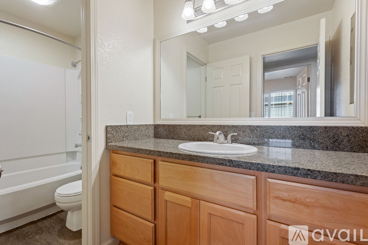 A bathroom with a sink, mirror, and bathtub.